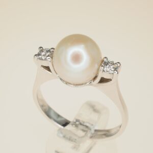 Anello con perla giapponese 3/4 e 2 brillanti ai lati      oro gr. 3,40, brillanti ct. 0,20     taglia 16